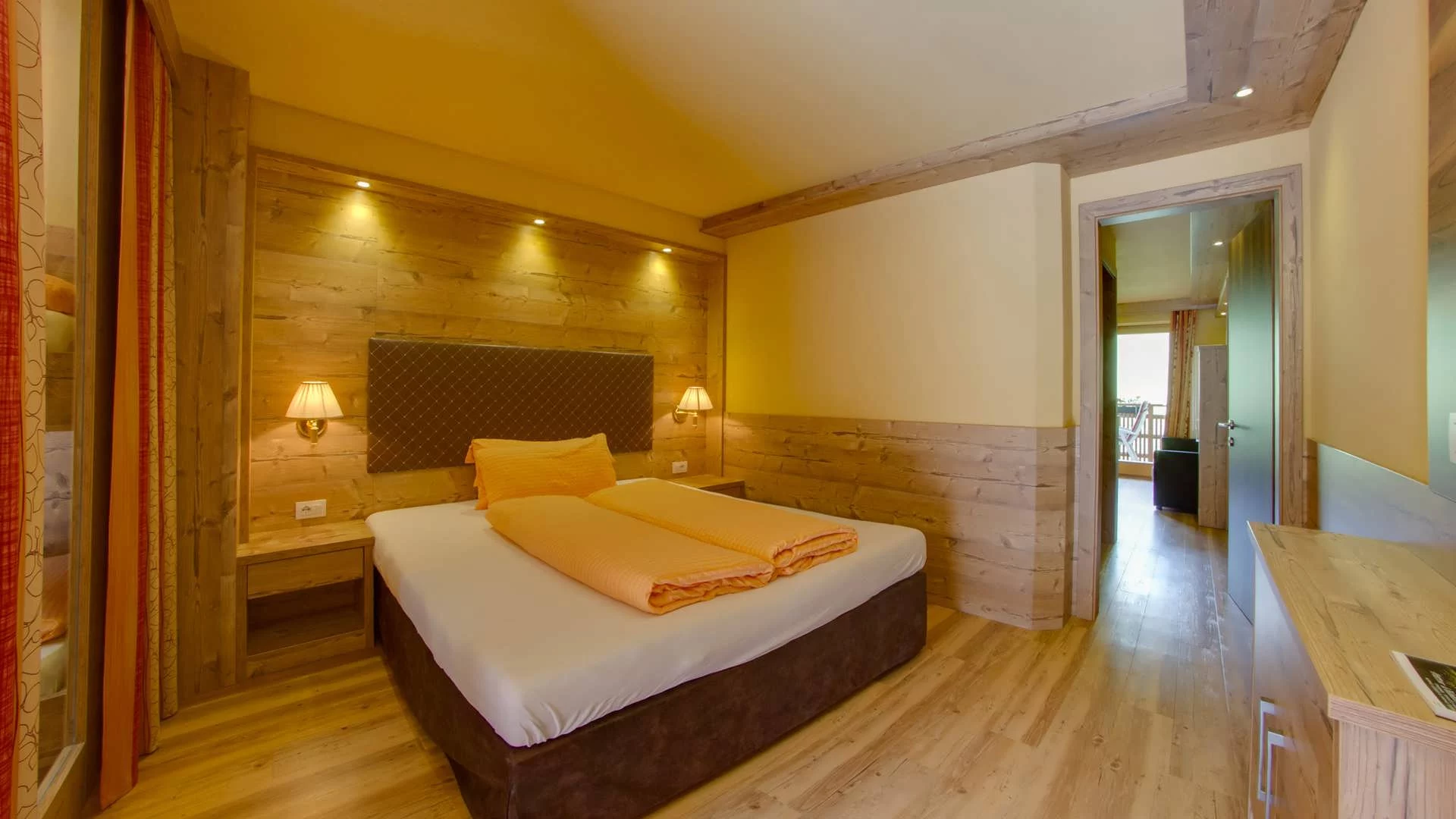 Doppelzimmer im Appartement Typ A Panorama mit warmem Holz und Blick in den Wohnbereich