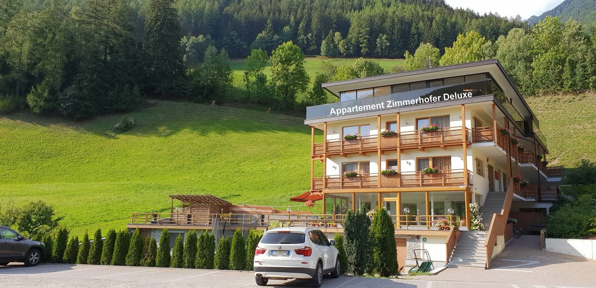 Zimmerhofer Appartements Deluxe in Steinhaus vor grünen Wiesen und Wald