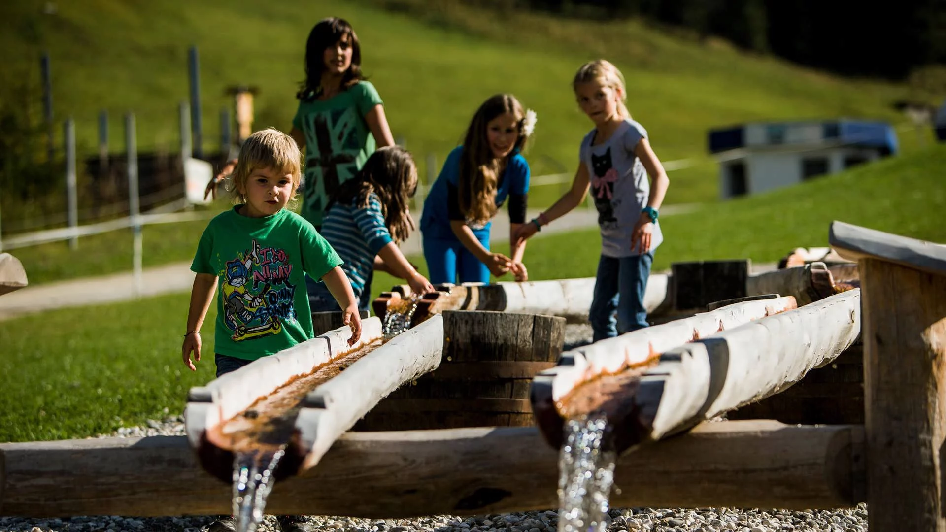 Kinder spielen im Sommer mit Wasser am Klausberg